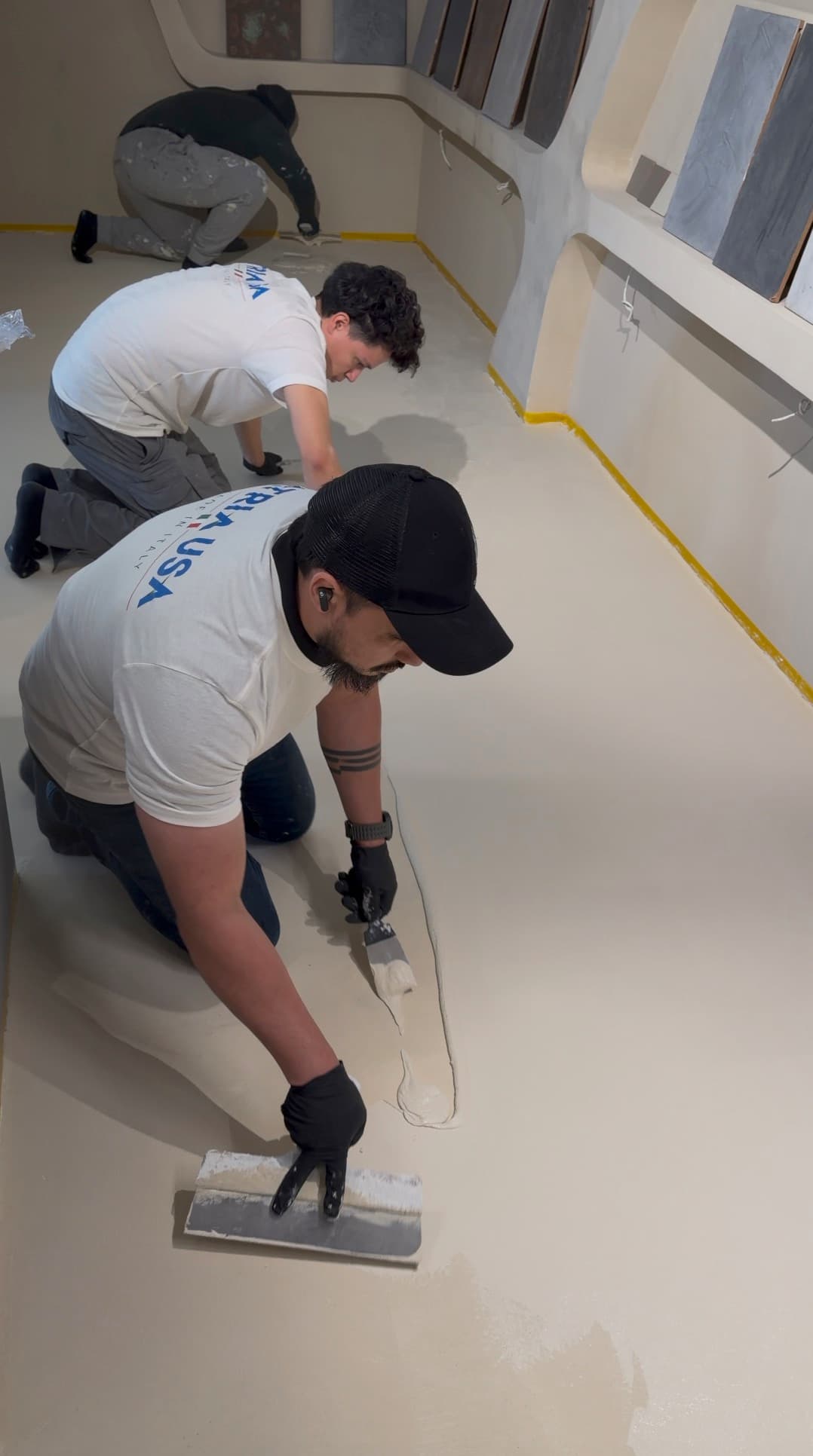 Dallas crew applying microcement in showroom, overhead angle