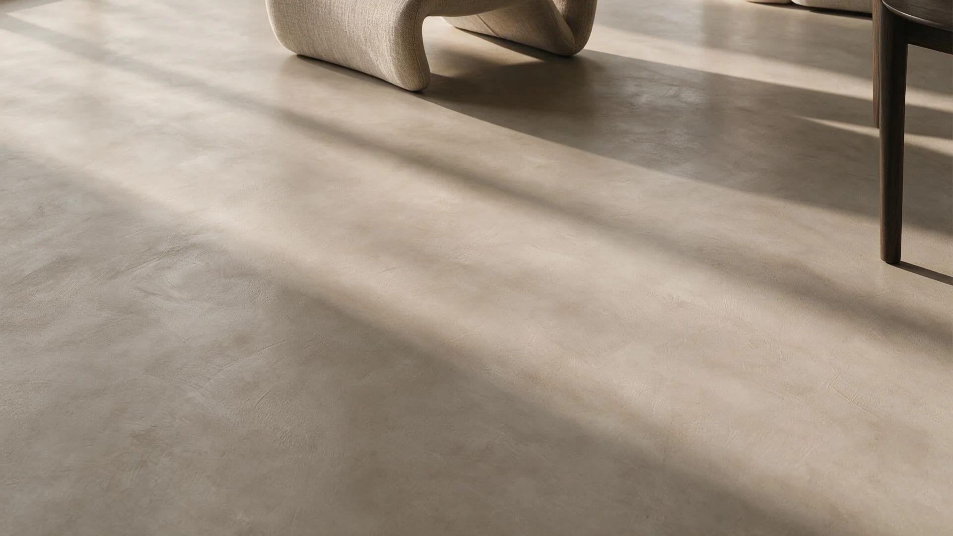 Seamless crack-free greige microcement floor in raking natural light