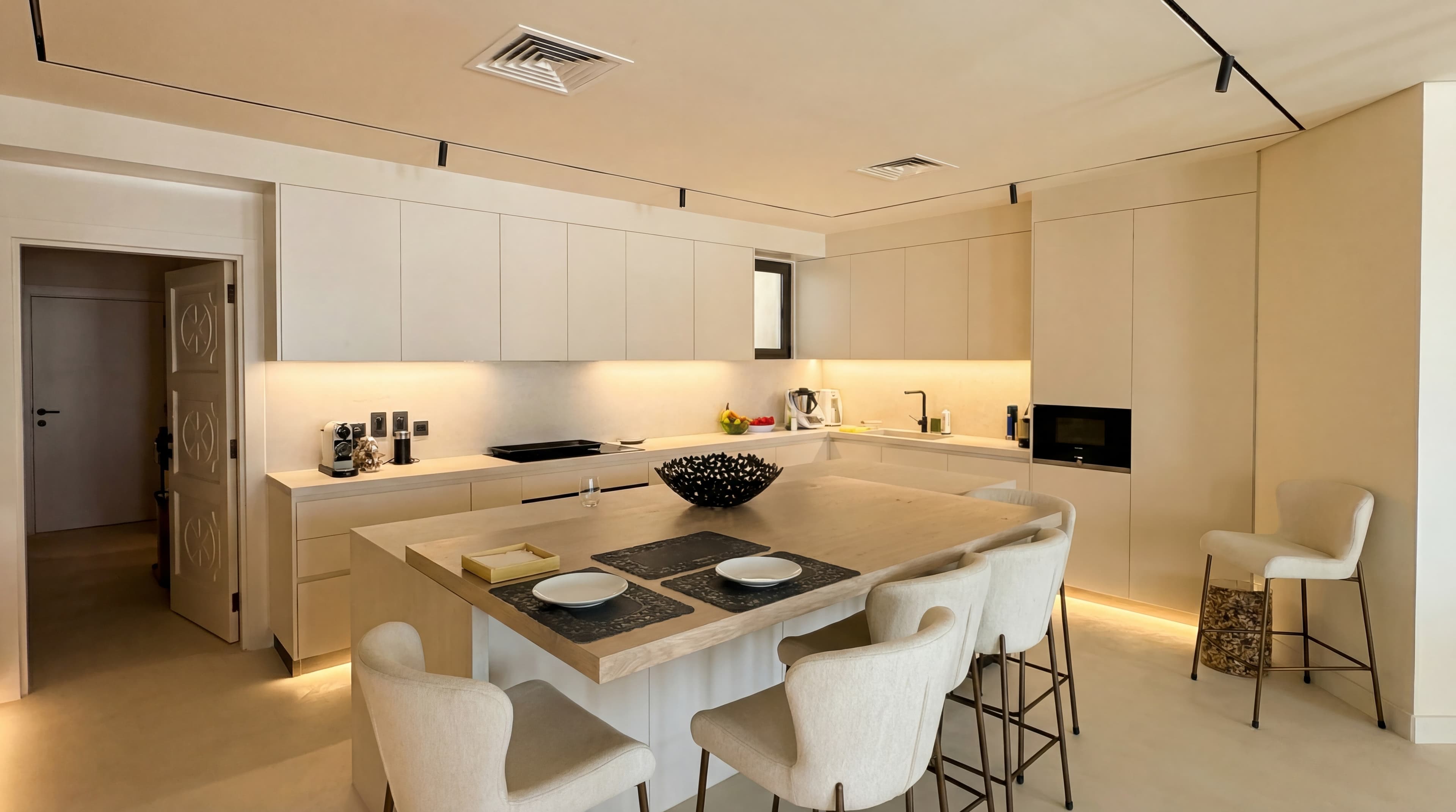 Cream Kitchen — Ornate carved door with island seating